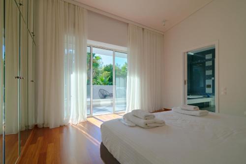 Posteľ alebo postele v izbe v ubytovaní Luxury Villa with Pool, BBQ & Garden in Vouliagmeni