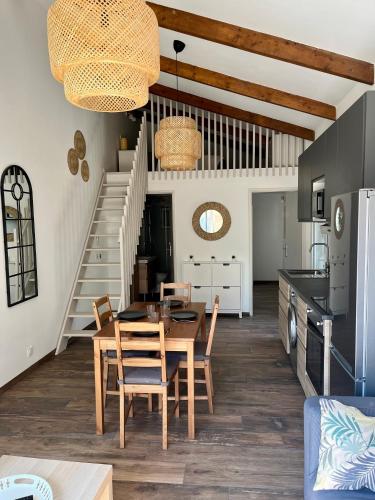 une salle à manger et une cuisine avec une table et des chaises dans l'établissement Maisonnette avec petite forêt, à Valréas