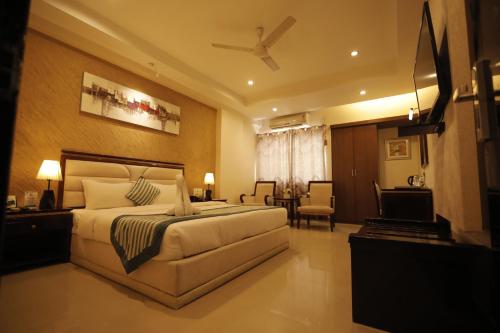 Un dormitorio con una cama y una sala de estar. en Hotel KRC Palace, en Tezpur
