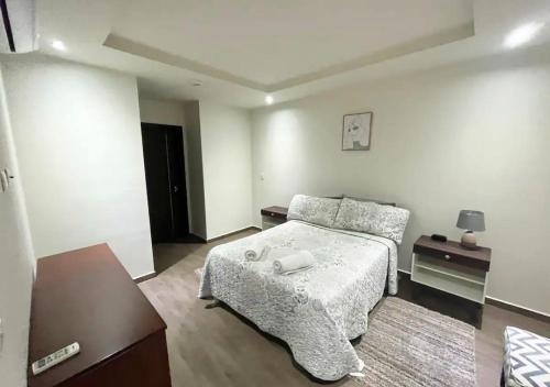 a small bedroom with a bed and a table at Apartamento Acogedor en un entorno Natural in Santa Ana