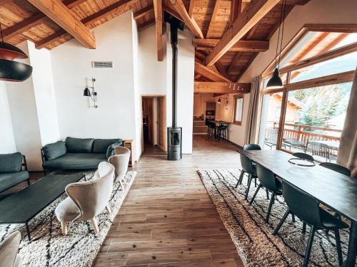 a living room with a long table and chairs at La Mélèzine, Cocon détente avec sauna in Le Monêtier-les-Bains