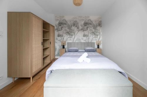 - une chambre avec un grand lit blanc dans l'établissement Le Royal - Appartement design - Hyper centre, à Vichy