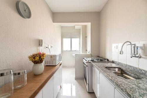 a white kitchen with a sink and a counter at Apartamento Em Santo André 3 Quartos e Garagem | Camilópolis in Santo André