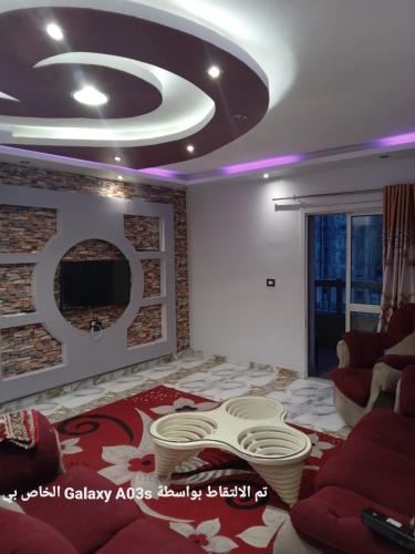 een woonkamer met een plafond met paarse verlichting bij الاسكندريه in Al Ḩamīdāt