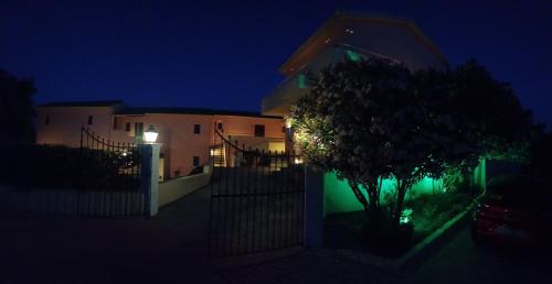 a house at night with a tree in front of it at Penelope Apartment Hotel in Dassia