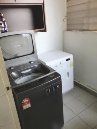 a kitchen with a washer and dryer in a room at teratak akilla in Putrajaya