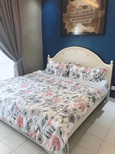 a bed with a floral comforter in a bedroom at teratak akilla in Putrajaya