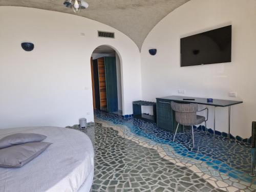 a bedroom with a bed and a desk with a television at HOLIDAY double in Praiano