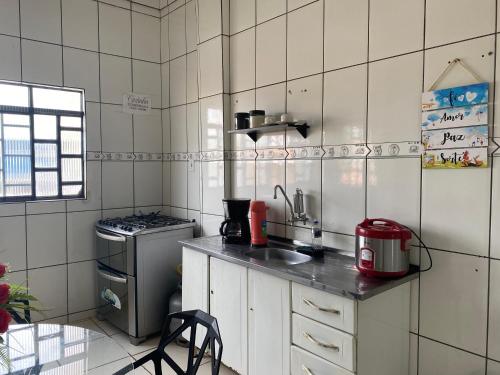 a small kitchen with a sink and a stove at João eudes Rodrigues de Souza in Marabá