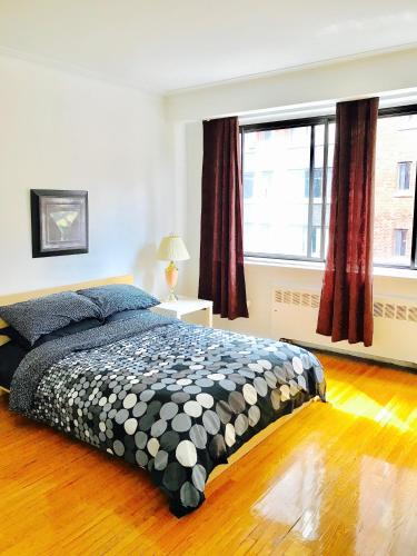 a bedroom with a bed and a large window at Stylish Montreal Apartment: Comfortable Stay in the Golden Square Mile in Montreal