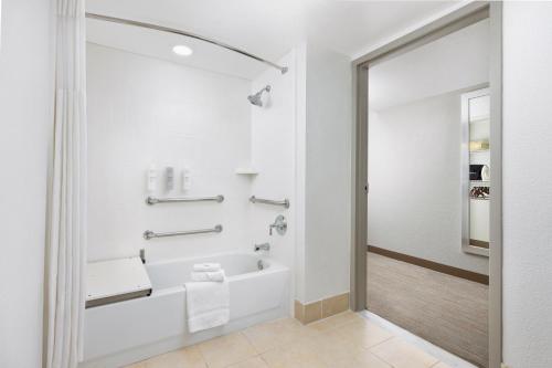 a white bathroom with a tub and a shower at Hampton Inn Naples-Central in Naples
