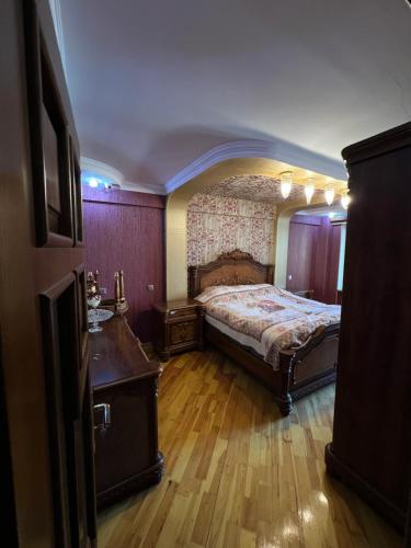 1 dormitorio con 1 cama y suelo de madera en Genclik, en Baku