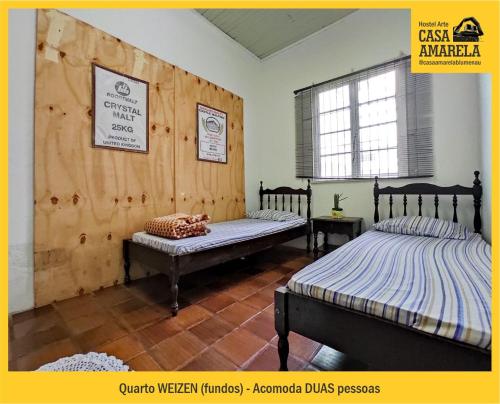 a bedroom with two beds and a window at Casa Amarela Blumenau Hospedagem Alternativa in Blumenau