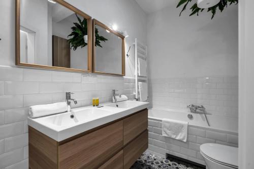 a bathroom with a sink and a tub and a toilet at Spiralna 3-Bedroom Apartment in Warsaw