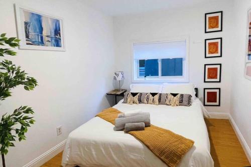 a white bedroom with a bed and a window at Artist's retreat near the heart of the city in Sacramento