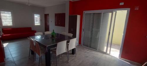a dining room with a table and white chairs at Casa Chuchi in Reconquista
