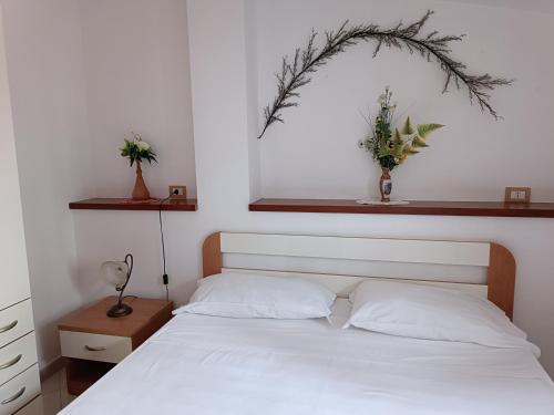 um quarto com uma cama branca e uma área por cima. em Residence La Playa em Marina di Camerota
