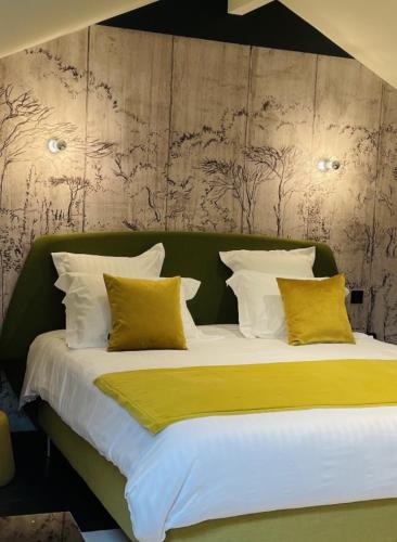 a bedroom with a large bed with yellow pillows at La Maison Ruffinoise in Sainte-Ruffine