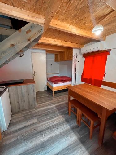 Pokój z drewnianym stołem i łóżkiem w obiekcie Koča Janka in Metke w mieście Velika Loka