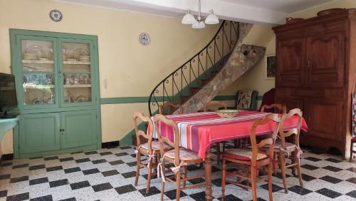 une salle à manger avec une table, des chaises et un escalier dans l'établissement Maison de famille, à Razecueillé