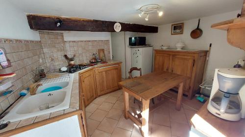 a kitchen with a tub and a table and a sink at Maison ancienne in Razecueillé