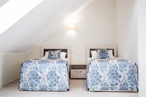 2 camas en un ático con sábanas azules y blancas en Sanatorija ,,Tulpės", en Birštonas