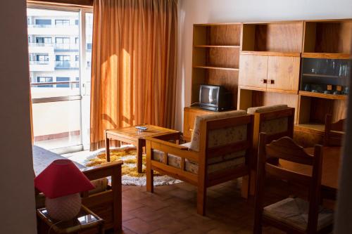 a living room with a desk and a table with a chair at Columbia Apartamentos Turisticos in Portimão