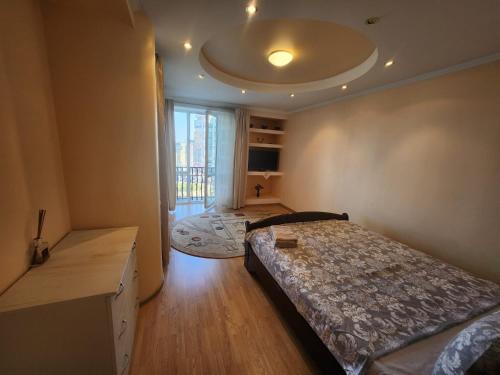 ein Schlafzimmer mit einem Bett und einem großen Fenster in der Unterkunft Modern Vision 1-room Apartament in Hipermarket Nr-1 in Chişinău