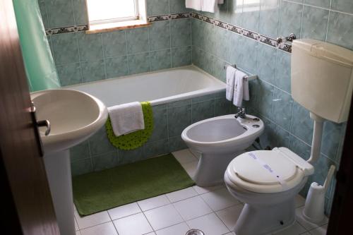 un bagno con lavandino, WC e vasca di Columbia Apartamentos Turisticos a Portimão