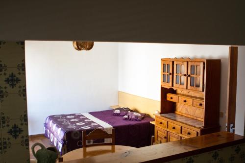 una camera da letto con un letto e una cassettiera in legno di Columbia Apartamentos Turisticos a Portimão