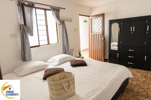 a bedroom with a bed with a bag on it at KOMODO ALOJAMIENTO- hostal autoservicio - ubicado muy cerca al centro histórico -Habitaciones con baño privado, wifi , cama 2x2 in Popayan