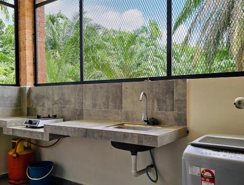 a kitchen counter with a sink and a window at BRIK 'N BATA in Batang Berjuntai