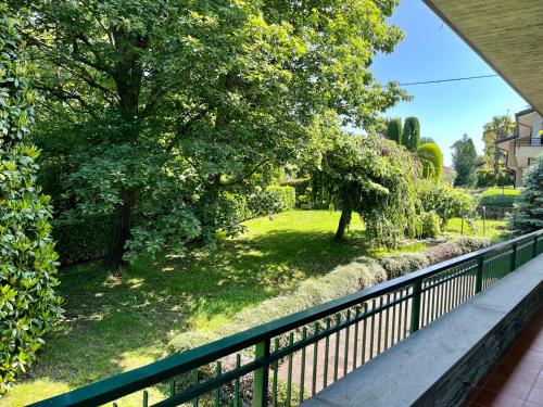 a balcony with a fence and a yard with trees at LUKAS HOME CON IL CUORE Appartamento 3 camere al piano terra e appartamento 1 camera in taverna in Merone