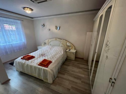 1 dormitorio con 1 cama con 2 toallas rojas en Star Street Home, en Mosonmagyaróvár
