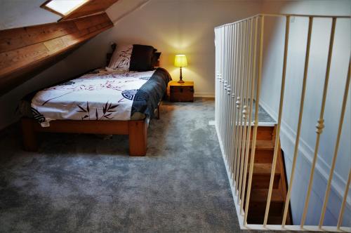 a small bedroom with a bed and a staircase at La lanterne in Gap