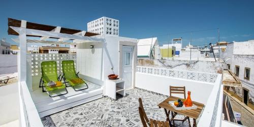 a balcony with a table and chairs on a roof at KASA BLANCA in Olhão