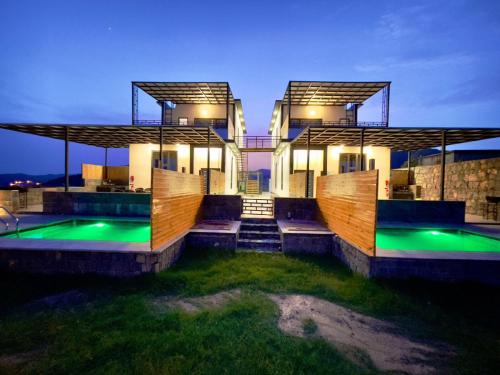 a house with two swimming pools in front of it at ALOEVERA VILLAS & CAFA in Sayq