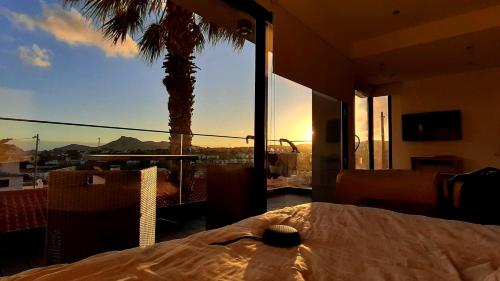a bedroom with a bed and a view of a palm tree at A Casa do Góis - Villa in Porto Santo in Porto Santo