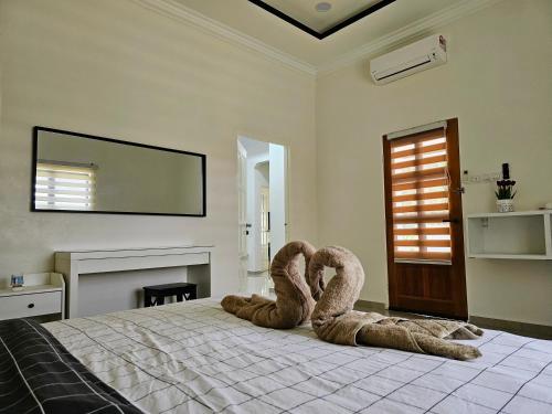 un dormitorio con dos cisnes sentados en una cama en BRIK 'N BATA en Batang Berjuntai