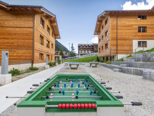 a pool table in the middle of a courtyard with buildings at Apartment SWISSPEAK Resorts Ober Gabelhorn by Interhome in Zinal