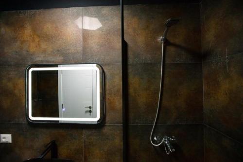 a mirror on the wall of a bathroom with a shower at Luxury Apartment at Condor Center in Tirana