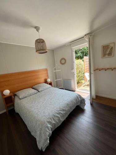 a bedroom with a bed and a sliding glass door at Villa Moana Soustons plage / Vieux-Boucau in Soustons