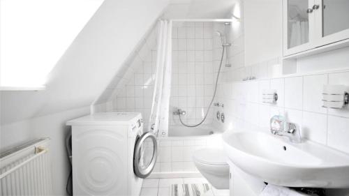 a white bathroom with a toilet and a sink at Zwei Ferienwohnungen in Randersacker in Randersacker