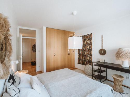een witte slaapkamer met een bed en een bureau bij Apartment Tauernspirit by Interhome in Bad Gastein