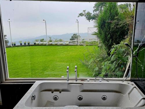 a sink in front of a window with a view of a field at The Bohemian Casa Dehradun in Dehradun