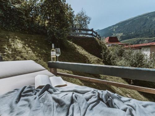 Una cama con dos libros y una copa de vino. en Chalet Chalet 1018 by Interhome, en Bad Gastein