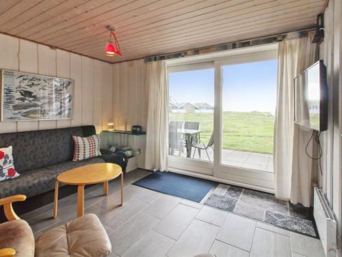 a living room with a couch and a large window at Apartment Gertruda - 2-3km from the sea in Western Jutland by Interhome in Havneby