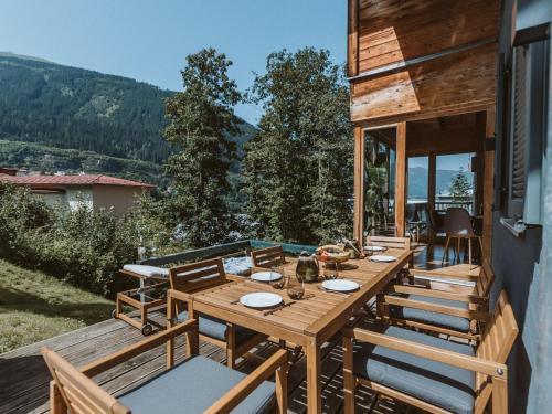 a wooden table and chairs on the deck of a house at Chalet Chalet 1018 by Interhome in Bad Gastein