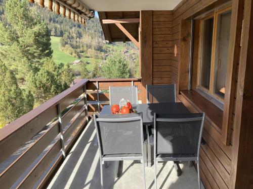 einen Tisch und Stühle auf dem Balkon einer Hütte in der Unterkunft Apartment Crocus by Interhome in Zweisimmen