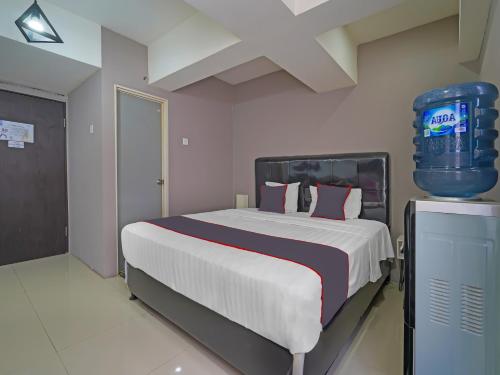 a bedroom with a large bed and a pepsi machine at OYO Life 92649 Jarrdin Apartment By Glory in Bandung